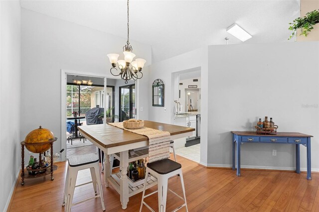 12512 Tillingham Ct SW, Orlando, FL 32837 - dining area with a chandelier, light wood-type flooring, and baseboards