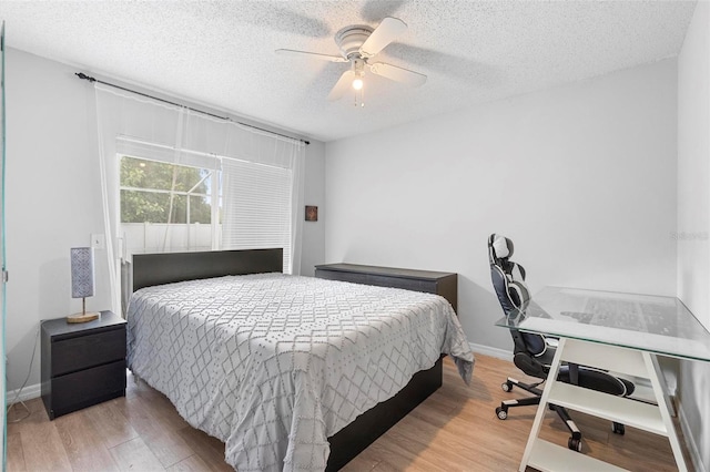 bedroom featuring a textured ceiling, light hardwood / wood-style flooring, and ceiling fan