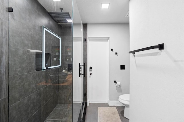 bathroom with toilet and a tile shower