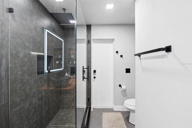 12512 Tillingham Ct SW, Orlando, FL 32837 - bathroom featuring a tile shower, toilet, and baseboards