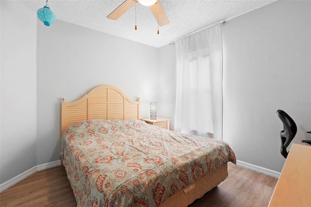 bedroom with wood-type flooring, a textured ceiling, and ceiling fan