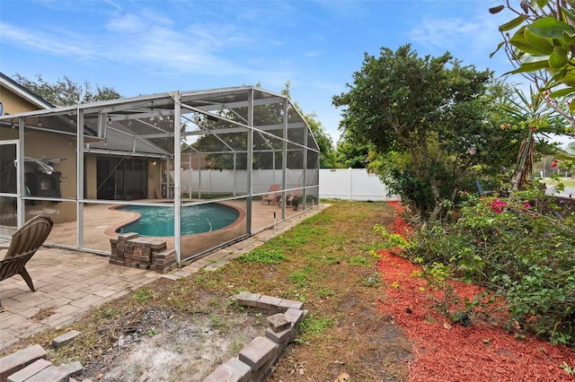 view of pool featuring glass enclosure and a patio area