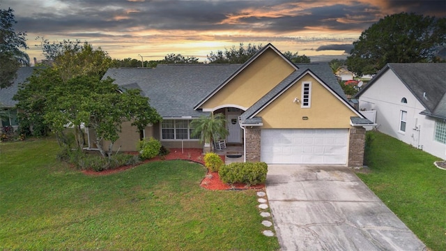 12512 Tillingham Ct SW, Orlando, FL 32837 - view of front of property featuring driveway, stucco siding, a lawn, a garage, and a shingled roof
