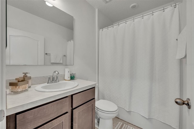 full bathroom with a textured ceiling, vanity, shower / tub combo, and toilet