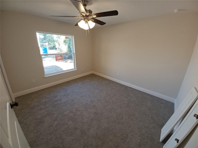 empty room featuring dark colored carpet, baseboards, and ceiling fan