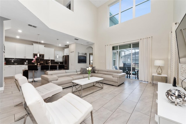 tiled living room featuring a high ceiling