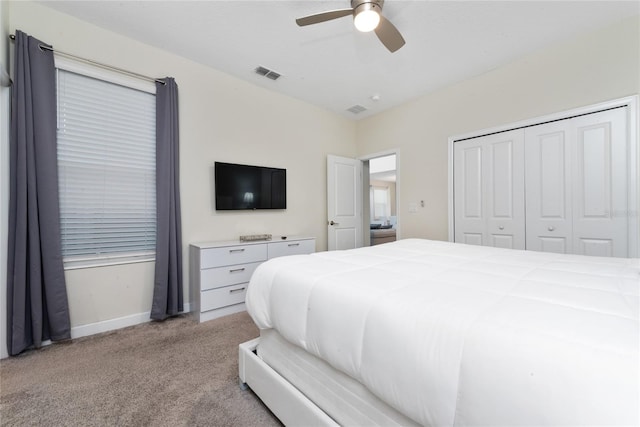 bedroom with a closet, light colored carpet, and ceiling fan