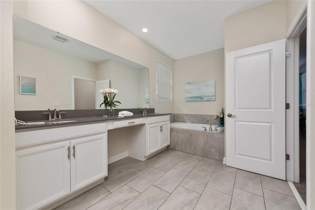 bathroom with vanity, a relaxing tiled tub, and tile patterned floors