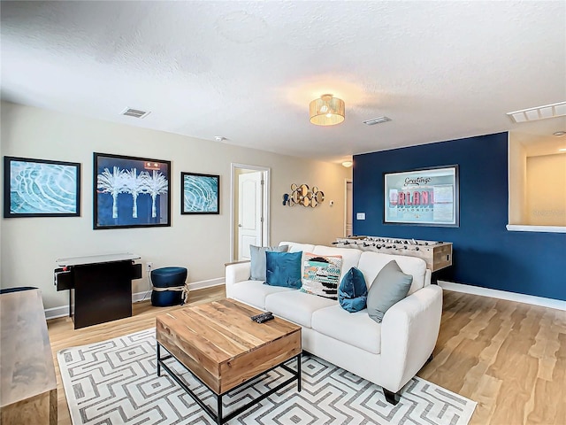 living room with a textured ceiling and light hardwood / wood-style floors