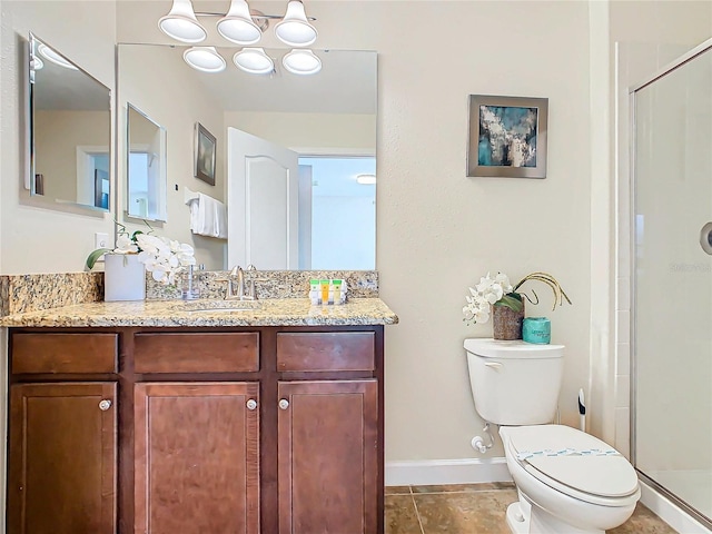 bathroom featuring tile patterned floors, vanity, a shower with shower door, and toilet