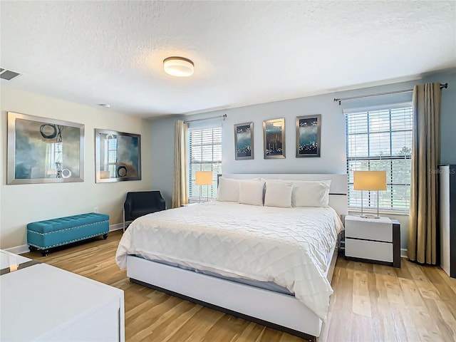 bedroom featuring a textured ceiling and light wood-type flooring