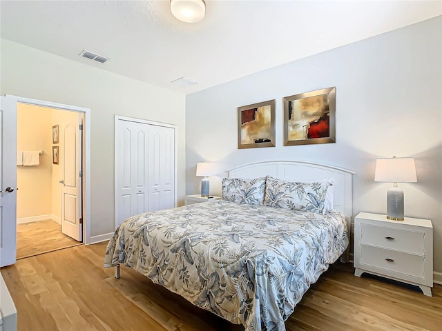 bedroom with connected bathroom, a closet, and light hardwood / wood-style floors