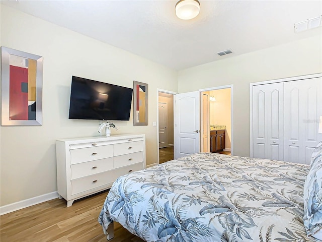 bedroom with light hardwood / wood-style floors and ensuite bath