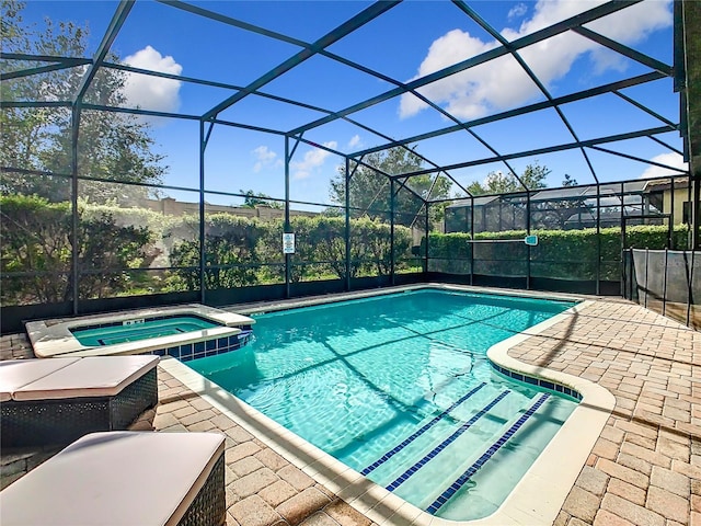 view of swimming pool featuring glass enclosure, an in ground hot tub, and a patio area