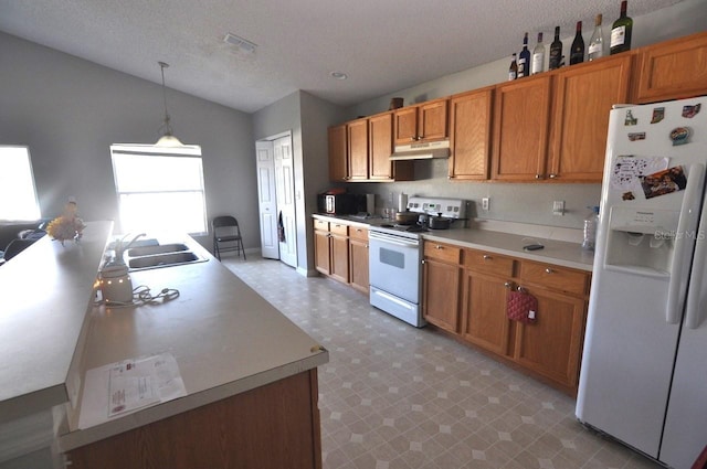 kitchen featuring white appliances, a textured ceiling, sink, and pendant lighting