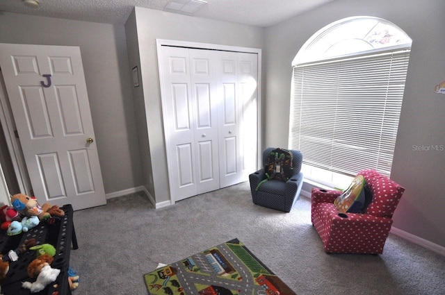 game room featuring a textured ceiling and carpet