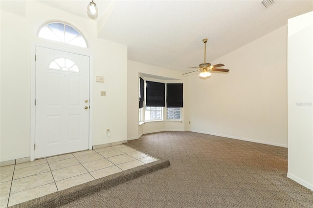 carpeted foyer entrance featuring ceiling fan and vaulted ceiling