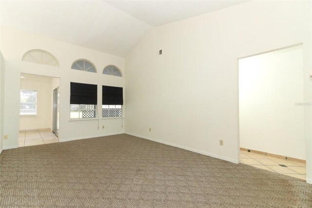 unfurnished room with light carpet and vaulted ceiling