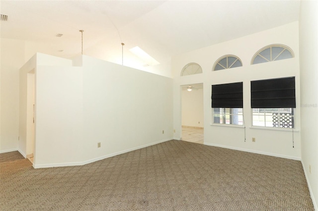 carpeted empty room featuring high vaulted ceiling