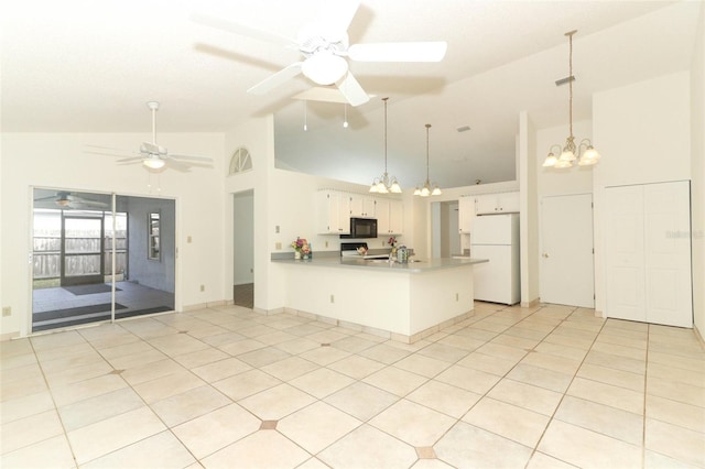 kitchen with kitchen peninsula, range, white cabinets, white fridge, and pendant lighting