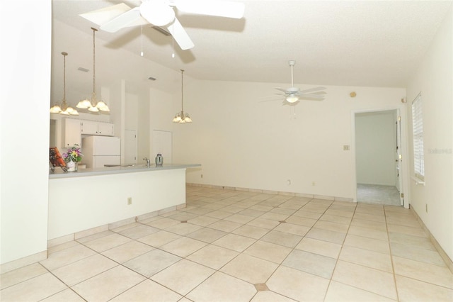 spare room featuring ceiling fan with notable chandelier, light tile patterned floors, and high vaulted ceiling