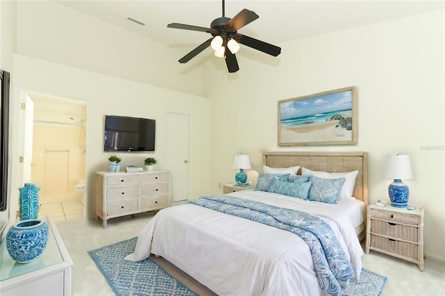 bedroom featuring ceiling fan, ensuite bath, and light tile patterned floors