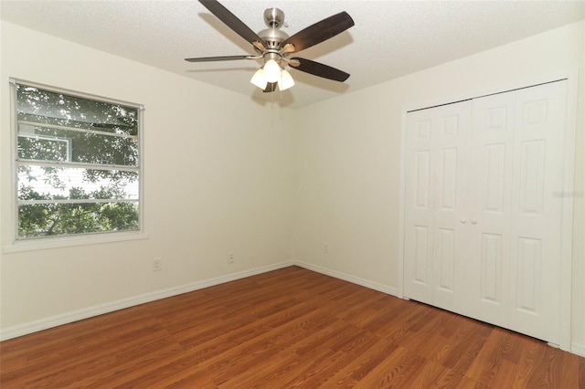 unfurnished bedroom featuring a textured ceiling, hardwood / wood-style floors, ceiling fan, and a closet