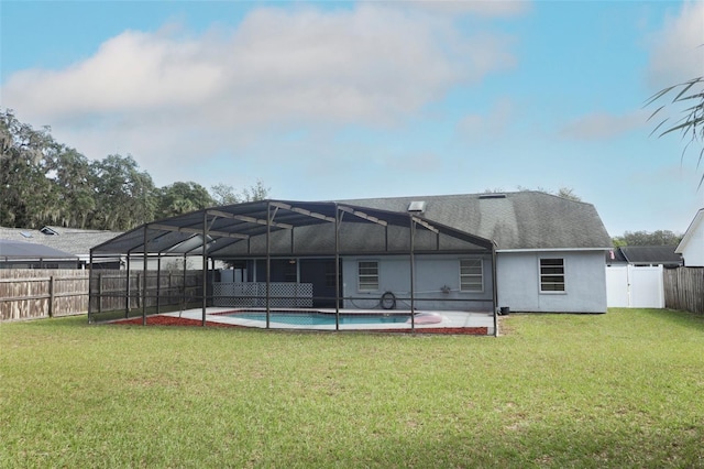 rear view of house featuring a lanai, a lawn, a fenced in pool, and a patio area