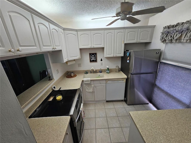 721 S Beach St Unit 217A, Daytona Beach, FL 32114 - kitchen with stainless steel appliances, white cabinetry, a textured ceiling, light tile patterned floors, and sink