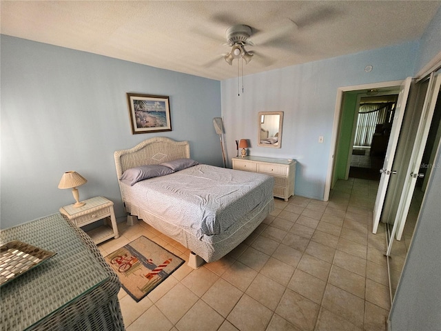 721 S Beach St Unit 217A, Daytona Beach, FL 32114 - bedroom with light tile patterned flooring, a textured ceiling, and ceiling fan
