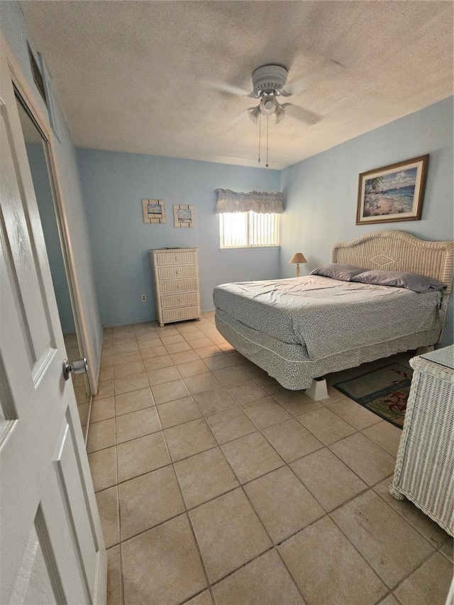 721 S Beach St Unit 217A, Daytona Beach, FL 32114 - tiled bedroom featuring ceiling fan and a textured ceiling