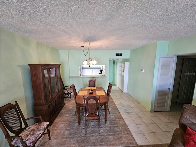 721 S Beach St Unit 217A, Daytona Beach, FL 32114 - tiled dining space featuring a chandelier and a textured ceiling