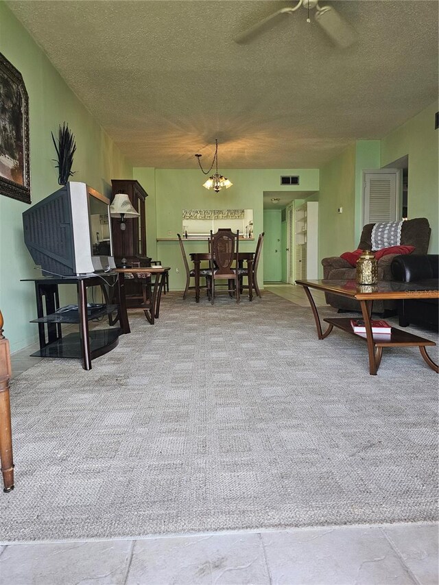 721 S Beach St Unit 217A, Daytona Beach, FL 32114 - living room featuring ceiling fan with notable chandelier, a textured ceiling, and carpet