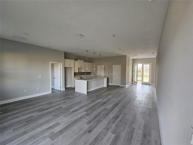 unfurnished living room with hardwood / wood-style floors and sink