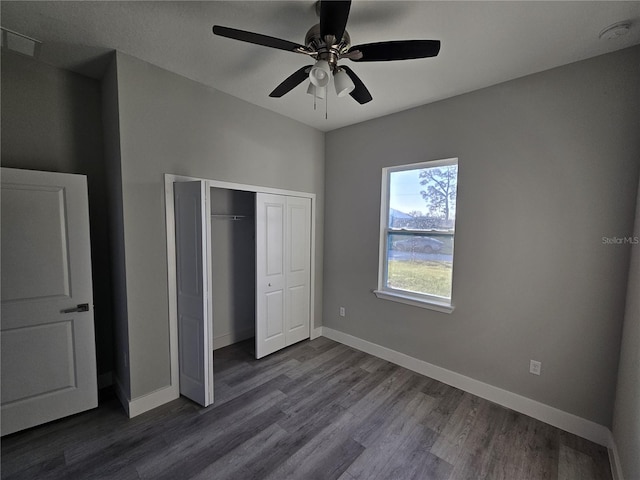 unfurnished bedroom featuring ceiling fan, dark wood-type flooring, and a closet