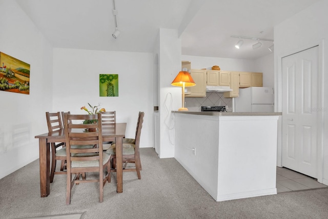 dining space featuring rail lighting and light carpet