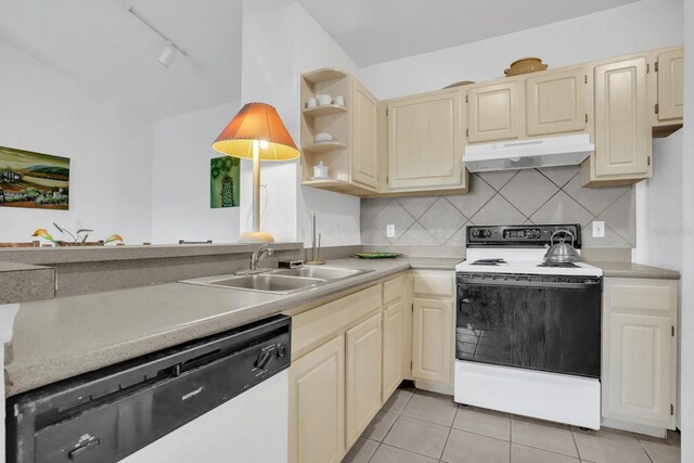 kitchen featuring sink, track lighting, light tile patterned floors, backsplash, and white appliances