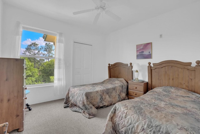 carpeted bedroom with ceiling fan and a closet