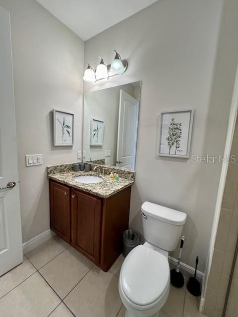 full bath featuring toilet, tile patterned floors, baseboards, and vanity