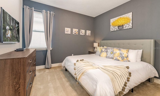 bedroom with light carpet and baseboards