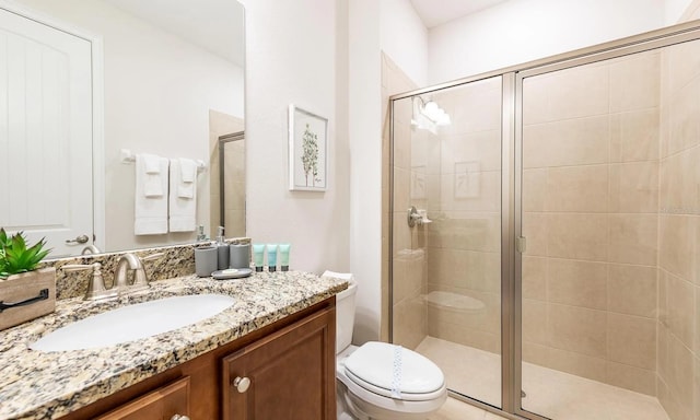 full bath featuring toilet, a shower stall, and vanity