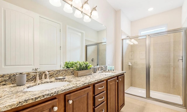 bathroom with a chandelier, double vanity, a sink, and a shower stall