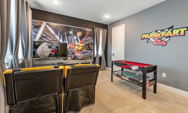 cinema room featuring baseboards and light colored carpet