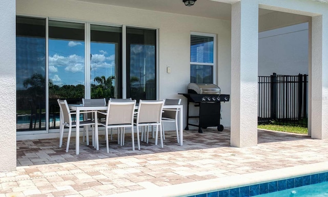 view of patio / terrace with a fenced in pool, outdoor dining area, fence, and grilling area