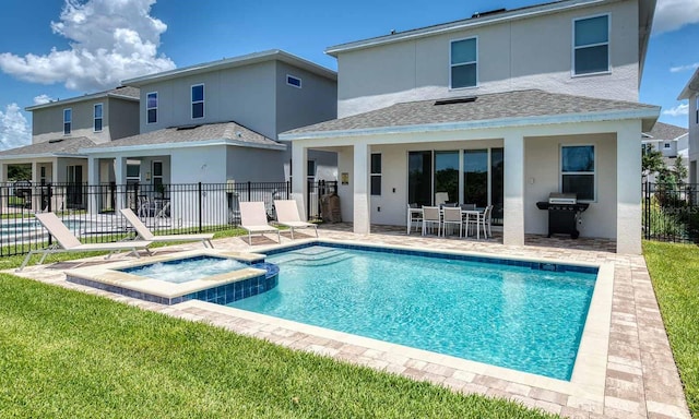 rear view of house featuring a patio, fence, a pool with connected hot tub, roof with shingles, and stucco siding