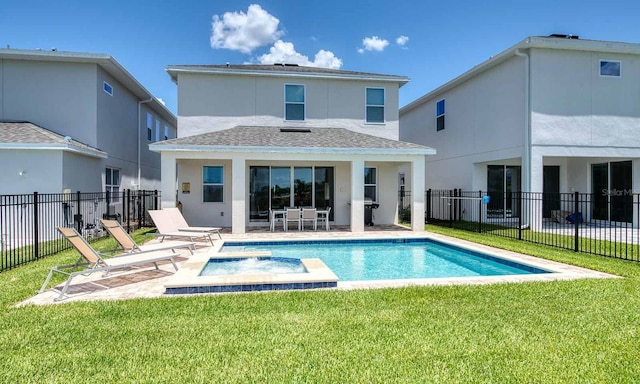 rear view of house with a lawn, a patio, fence, a pool with connected hot tub, and stucco siding