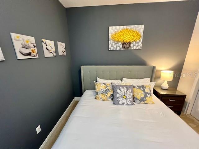 bedroom featuring carpet and baseboards