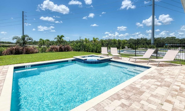 view of pool with a lawn, a patio area, fence, and a pool with connected hot tub