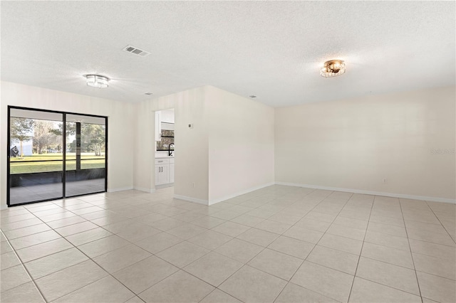 tiled spare room with a textured ceiling