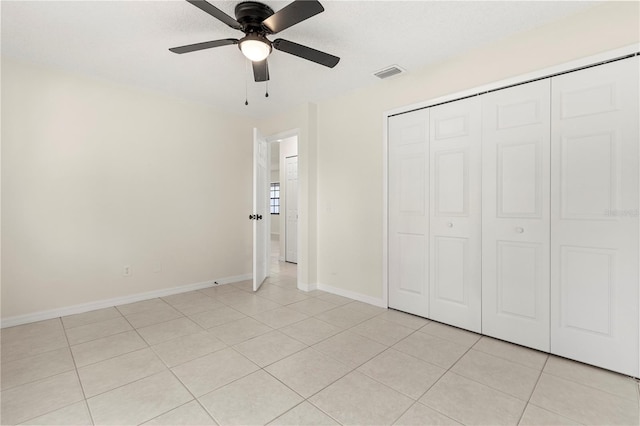 unfurnished bedroom featuring light tile patterned floors, ceiling fan, and a closet